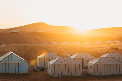 a group of white domes in the desert at Sanmao Royal Camp \u7687\u5bb6\u8425\u5730 in Merzouga