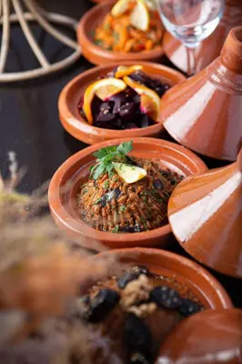 a table with brown plates of food on it at Sanmao Royal Camp \u7687\u5bb6\u8425\u5730 in Merzouga
