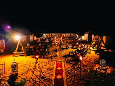 a beach at night with lights in the sand at Sanmao Royal Camp \u7687\u5bb6\u8425\u5730 in Merzouga