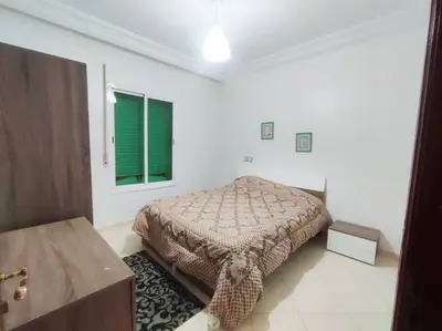 a bedroom with a bed in a white room at SkyRise Khemisset 2 : 2 bedrooms in Khemisset