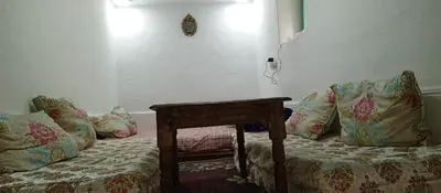a room with a bed with a table and pillows at Moulay Idriss in Moulay Idriss Zerhoun