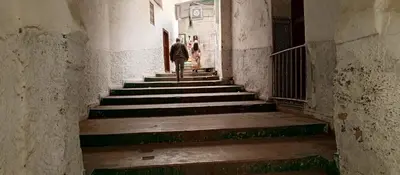 a man and woman walking down the stairs in an alley at Moulay Idriss in Moulay Idriss Zerhoun