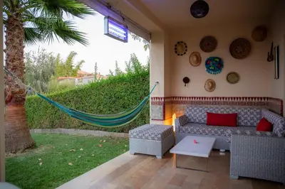 a patio with a couch and a hammock in a yard at ROYAL GOLF DE FES in Fès