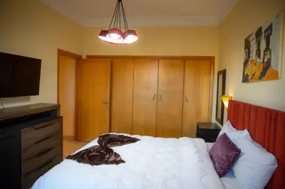 a bedroom with a white bed and a television at ROYAL GOLF DE FES in Fès