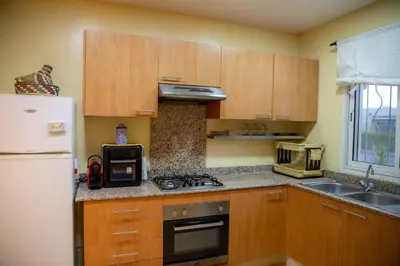 a kitchen with wooden cabinets and a stove top oven at ROYAL GOLF DE FES in Fès