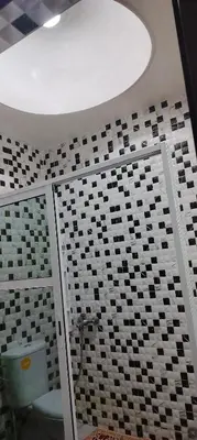 a bathroom with a toilet and a tile wall at DAR LAAZIZA in Meknès