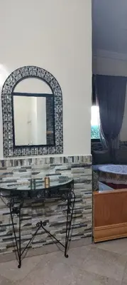 a dressing table with a mirror on a wall at DAR LAAZIZA in Meknès