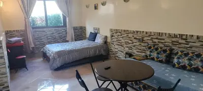 a bedroom with a bed and a table and a couch at DAR LAAZIZA in Meknès