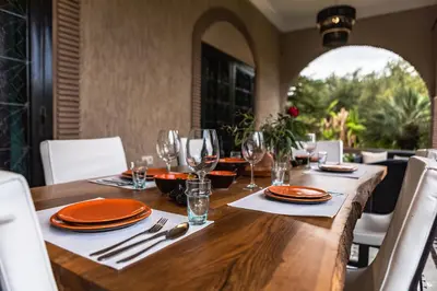 a wooden table with plates and wine glasses on it at Just V hotel & Spa in Marrakech