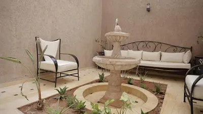 a fountain in a room with chairs and a couch at Just V hotel & Spa in Marrakech
