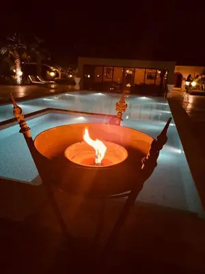 a fire pit in front of a pool at night at Just V hotel & Spa in Marrakech