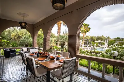 an outdoor patio with a wooden table and chairs at Just V hotel & Spa in Marrakech