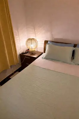 a bedroom with a bed and a lamp on a night stand at Spacious Apartment with Motorcycle Garage, Free Parking, and Air Conditioning in Er Rachidia
