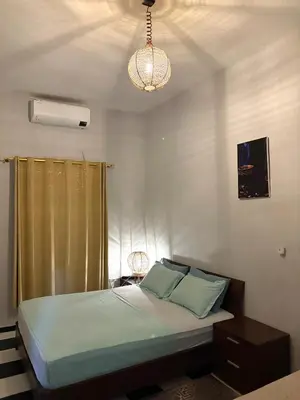 a bedroom with a bed and a chandelier at Spacious Apartment with Motorcycle Garage, Free Parking, and Air Conditioning in Er Rachidia