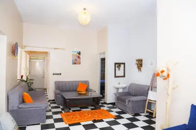 a living room with two couches and a checkered floor at Spacious Apartment with Motorcycle Garage, Free Parking, and Air Conditioning in Er Rachidia