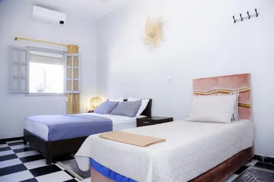 a bedroom with two beds and a checkered floor at Spacious Apartment with Motorcycle Garage, Free Parking, and Air Conditioning in Er Rachidia