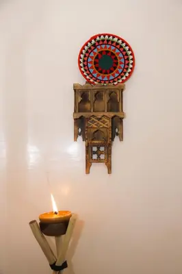 a candle and a plate on a wall at Spacious Apartment with Motorcycle Garage, Free Parking, and Air Conditioning in Er Rachidia