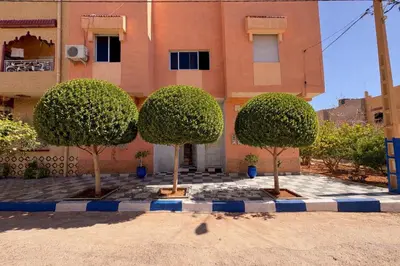 three trees in front of a building at Spacious Apartment with Motorcycle Garage, Free Parking, and Air Conditioning in Er Rachidia