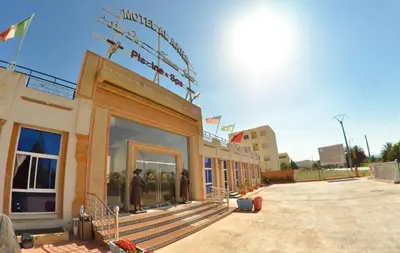 a building with people standing outside of it at Hotel Al Akha in Sidi Harazem