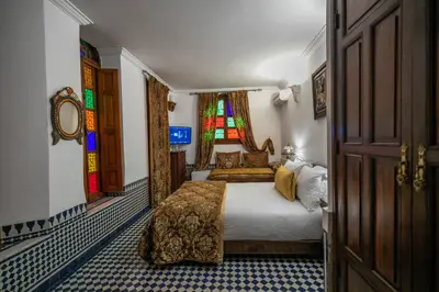 a bedroom with a bed and a stained glass window at La Perle de La Medina in Fès