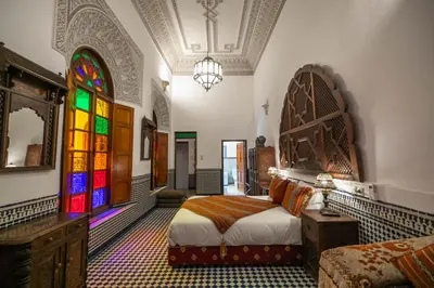 a bedroom with a bed and a stained glass window at La Perle de La Medina in Fès
