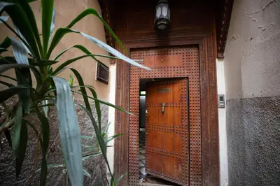 a wooden door in a building with a plant at La Perle de La Medina in Fès