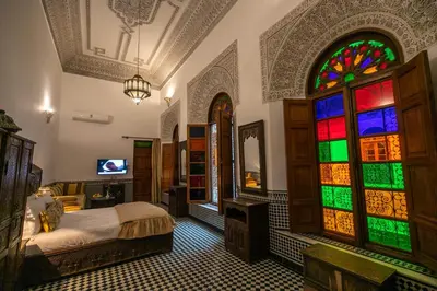 a bedroom with a bed and stained glass windows at La Perle de La Medina in Fès