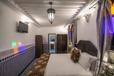 a bedroom with a bed and a tv in a room at La Perle de La Medina in Fès