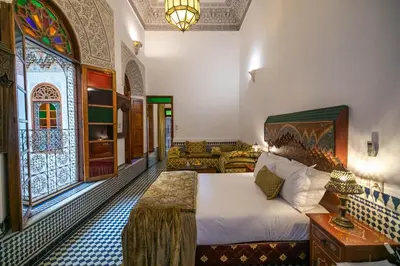a bedroom with a bed and a living room at La Perle de La Medina in Fès