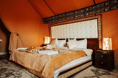 a bedroom with a large bed in a tent at Sahara Luxury Camp in Merzouga