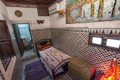 a room with a tiled wall with a bench in it at Dar Chourouk in Fès