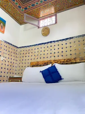 a bedroom with a bed and a clock on the wall at Dar Chourouk in Fès