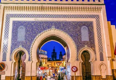 a building with an arch with a city in the background at Dar Chourouk in Fès