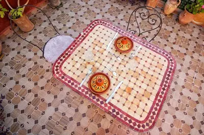 a chess board on a tiled floor with two candles at Dar Chourouk in Fès