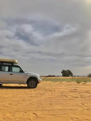 a car parked on a dirt road in the desert at Guesthubcamp in Merzouga