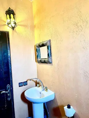 a bathroom with a sink and a mirror on the wall at Dar Hassi Labied Merzouga in Hassilabied