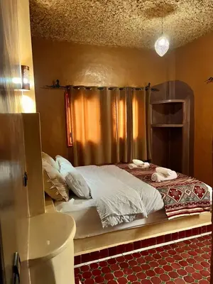 a bedroom with a large bed in a room at Dar Hassi Labied Merzouga in Hassilabied