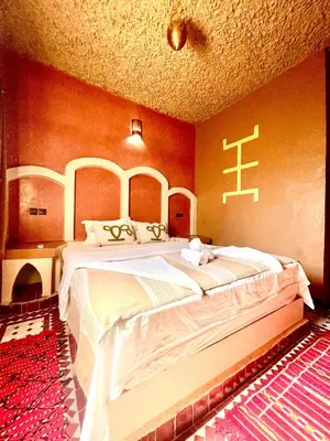 a bedroom with a large bed in a room at Dar Hassi Labied Merzouga in Hassilabied