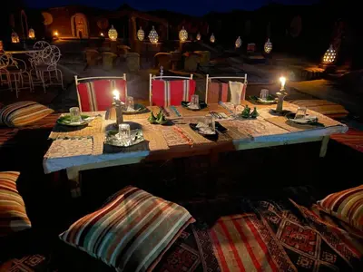a table with two candles on top of it at Desert Chegaga Luxury Camp in El Gouera