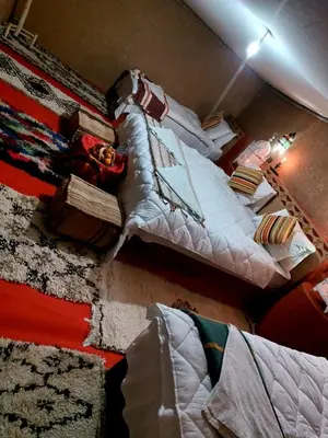a bedroom with two beds with white pillows at Desert Chegaga Luxury Camp in El Gouera