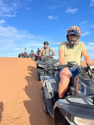 a group of people riding on atvs in the desert at Desert Chegaga Luxury Camp in El Gouera