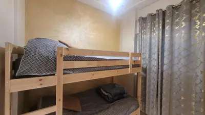 a bunk bed in a room with a curtain at Charme & Confort au Cœur de Meknes in Meknès
