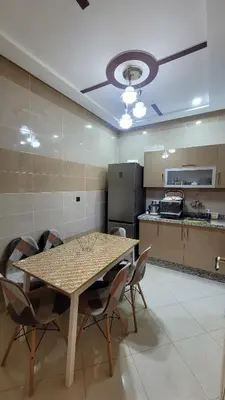 a dining room with a table and chairs and a kitchen at Charme & Confort au Cœur de Meknes in Meknès