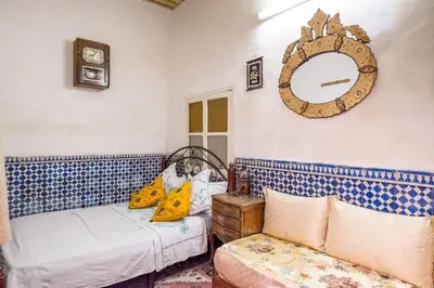 a bedroom with two beds and a mirror on the wall at Dar Fatimazahra in Fès