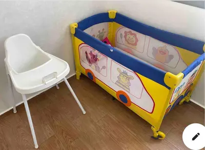 a crib and a chair in a room at Appartement centre-ville avec Wifi 100 Mo in Fès