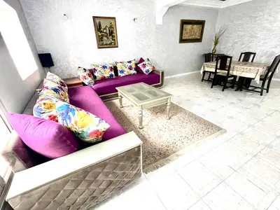 a living room with a purple couch and a table at Appartement centre-ville avec Wifi 100 Mo in Fès