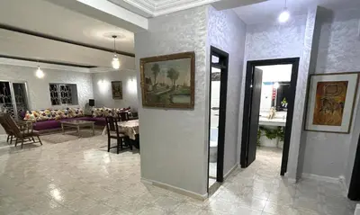 a living room with a table and a dining room at Appartement centre-ville avec Wifi 100 Mo in Fès