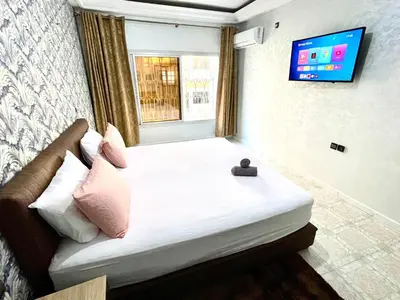a bedroom with a large bed with a television on the wall at Appartement centre-ville avec Wifi 100 Mo in Fès