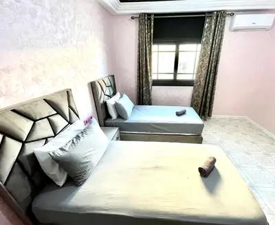 a small room with two beds and a window at Appartement centre-ville avec Wifi 100 Mo in Fès