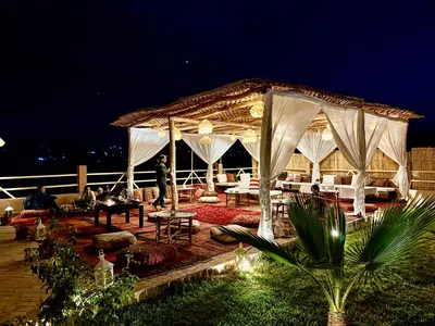 a pavilion with people sitting under it at night at Riad Sahara Stars Dades in Boumalne